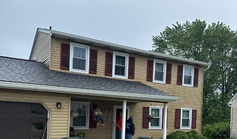 Two-story home exterior remodel with new roof, siding, and covered porch in Macungie, PA